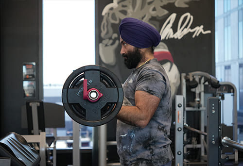 Person lifting a weight plate in a gym